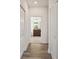 Hallway view into a bathroom with wood-look floors and white doors at 8983 Azalea Sands Ln # 8983, Davenport, FL 33896