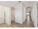A well-lit hallway with luxury vinyl plank flooring includes a laundry closet and access to other living spaces at 8983 Azalea Sands Ln # 8983, Davenport, FL 33896