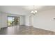 Spacious living area with modern light fixture, white walls, and sliding doors to balcony at 8983 Azalea Sands Ln # 8983, Davenport, FL 33896