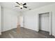 A modern bedroom with luxury vinyl plank floors features a ceiling fan and double closets for ample storage at 8983 Azalea Sands Ln # 8983, Davenport, FL 33896