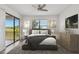 Cozy bedroom featuring a queen-size bed, ceiling fan, and sliding glass door with a scenic view at 8983 Azalea Sands Ln # 8983, Davenport, FL 33896