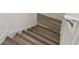 Staircase features luxury vinyl plank flooring, complemented by white walls and a handrail for safe navigation at 8983 Azalea Sands Ln # 8983, Davenport, FL 33896