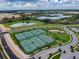 Aerial view showcasing a tennis court complex, surrounded by ponds, greenery, and well-maintained landscaping at 8983 Azalea Sands Ln # 8983, Davenport, FL 33896