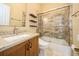 Modern bathroom with a sleek vanity, floating shelves, and a tiled shower-tub combination, offering style and functionality at 1002 Periwinkle Ct, Celebration, FL 34747