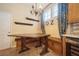 Charming dining nook with a rustic table, bench seating and modern chandelier at 1002 Periwinkle Ct, Celebration, FL 34747