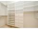 Spacious walk-in closet has custom white shelving and storage with drawers at 1002 Periwinkle Ct, Celebration, FL 34747