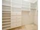 Spacious walk-in closet has custom white shelving and storage with drawers at 1002 Periwinkle Ct, Celebration, FL 34747