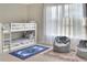 Bedroom with bunkbeds, sitting chairs, large window and alphabet-themed area rug at 1802 Royal Ridge Dr, Davenport, FL 33896