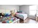 Cozy bedroom featuring two twin beds, a window for natural light, and modern wood flooring at 319 Bailey Cir, Davenport, FL 33897