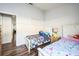 Bright bedroom featuring two twin beds, a window for natural light, and modern wood flooring at 319 Bailey Cir, Davenport, FL 33897