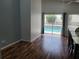 Dining room with wood floors, large glass doors, and view of the backyard pool area at 319 Bailey Cir, Davenport, FL 33897