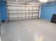 Spacious garage with epoxy flooring, blue accent wall, and bright overhead lighting at 319 Bailey Cir, Davenport, FL 33897