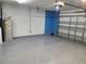 Clean garage with epoxy flooring, blue accent wall, water heater, and bright overhead lighting at 319 Bailey Cir, Davenport, FL 33897