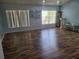 Open living room with hardwood floors, two windows providing natural light, and modern decor at 319 Bailey Cir, Davenport, FL 33897