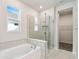 Bathroom showcases a glass-enclosed shower and separate soaking tub with tiled walls at 5932 Bristle Oak St, Mount Dora, FL 32757