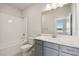 Modern bathroom features a tub and shower combo, a gray vanity, and a large mirror at 5932 Bristle Oak St, Mount Dora, FL 32757