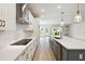 Bright kitchen features a gray island, quartz countertops, stainless appliances and pendant lighting at 5932 Bristle Oak St, Mount Dora, FL 32757