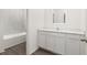 Bathroom featuring a single vanity with quartz countertops, white cabinets, and a tub and shower combo at 1633 Nantucket Way, Winter Haven, FL 33884
