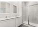 Bathroom featuring double vanity with quartz countertops, white cabinets, and a glass enclosed shower at 1633 Nantucket Way, Winter Haven, FL 33884