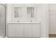 Bright bathroom boasts double sinks, quartz counters, and a glass shower door at 1645 Nantucket Way, Winter Haven, FL 33884