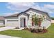 Inviting single-story home displaying a well-kept lawn, two-car garage, and vibrant red door and window accents at 1782 White Elephant Loop, Winter Haven, FL 33884