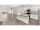 Bright, modern kitchen featuring stainless steel appliances, a functional island, and sleek, light-toned wood flooring at 1782 White Elephant Loop, Winter Haven, FL 33884
