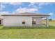 Exterior shot of backyard with patio and grass, featuring a neutral-colored home at 1802 White Elephant Loop, Winter Haven, FL 33884