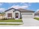 Charming single-story home with a well-manicured lawn, two car garage, and inviting front door at 1802 White Elephant Loop, Winter Haven, FL 33884