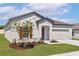 Stylish single-story house with a landscaped yard, attached two-car garage, and a welcoming entrance at 1802 White Elephant Loop, Winter Haven, FL 33884