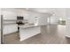 Open-concept kitchen featuring white cabinets, granite countertops, stainless steel appliances, and a large island at 1802 White Elephant Loop, Winter Haven, FL 33884
