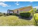 Lush backyard with a screened-in patio, manicured lawn, and mature trees providing privacy at 1892 Sanderling Dr, Clermont, FL 34711