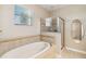 Bathroom features a separate shower and bathtub, with tiled surround at 1892 Sanderling Dr, Clermont, FL 34711