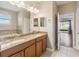 Bathroom features a double sink vanity with granite countertops, large mirror, and tiled floor at 1892 Sanderling Dr, Clermont, FL 34711