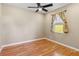 Cozy bedroom with wood-look flooring, ceiling fan, and a window with decorative curtains at 1892 Sanderling Dr, Clermont, FL 34711