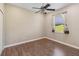 This cozy bedroom features wood-look laminate flooring and a window with blinds and curtains at 1892 Sanderling Dr, Clermont, FL 34711