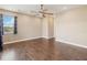 Spacious bedroom with dark wood floors, ceiling fan, recessed lighting, and a window with blue curtains at 1892 Sanderling Dr, Clermont, FL 34711