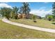 Attractive home situated on a well-maintained lawn, complemented by lush landscaping and swaying palm trees at 1892 Sanderling Dr, Clermont, FL 34711