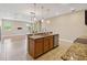 Kitchen island with stone countertops, stainless steel dishwasher, and overhead lighting at 1892 Sanderling Dr, Clermont, FL 34711