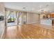 Open-concept living area with hardwood floors and doors to a screened porch and kitchen at 1892 Sanderling Dr, Clermont, FL 34711