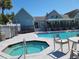 Community pool and jacuzzi area with plenty of seating surrounded by a black fence at 3700 Idlebrook Cir # 206, Casselberry, FL 32707