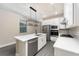 Modern kitchen featuring white cabinets, stainless steel appliances, and a large island with a sink at 7701 Somersworth Dr, Kissimmee, FL 34747