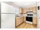 A well-lit kitchen features wood-look flooring, matching cabinets, and a white refrigerator at 3930 Cassia Dr, Orlando, FL 32828