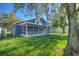 The spacious backyard includes a screened porch, green lawn, and a white picket fence at 14610 Astina Way, Orlando, FL 32837