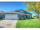 Charming blue two-story home featuring an attached two-car garage and a well-maintained front yard at 14610 Astina Way, Orlando, FL 32837