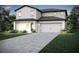 Charming two-story home featuring white siding, a two-car garage, and manicured landscaping at 1774 White Elephant Loop, Winter Haven, FL 33884