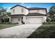 Charming two-story home features a large garage, a welcoming entrance and beautiful landscaping at 1799 White Elephant Loop, Winter Haven, FL 33884