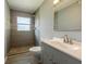 Bathroom featuring gray tiled shower, gray walls, a white toilet and shower, and bright vanity at 1326 Se 34Th Ter, Ocala, FL 34471