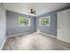 Bedroom with light gray walls, wood-look vinyl floors and two windows with a ceiling fan at 1326 Se 34Th Ter, Ocala, FL 34471