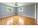 Bedroom with hardwood floors, light blue walls, ceiling fan and windows for bright natural light at 1326 Se 34Th Ter, Ocala, FL 34471