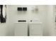 Efficient laundry room with white washer and dryer set, storage shelf, and ample space for laundry tasks at 2161 Albatross Nest Dr, Bartow, FL 33830